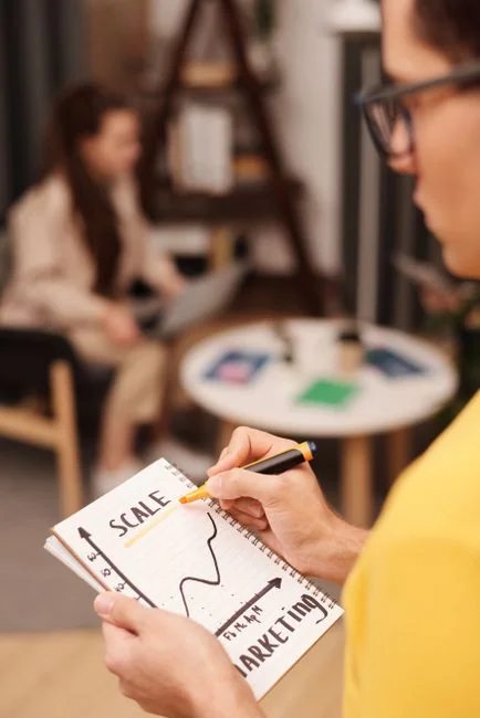 Un groupe diversifié élabore des stratégies marketing avec des graphiques et des ordinateurs portables dans un environnement de bureau.